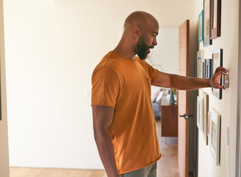 Man adjusting thermostat