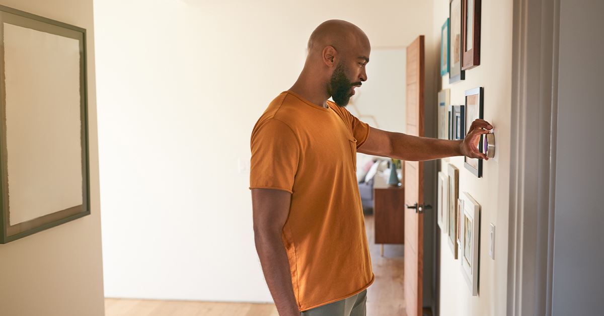 Man adjusting thermostat